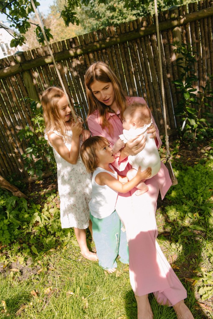 Trine Kjær i haven med sine tre børn