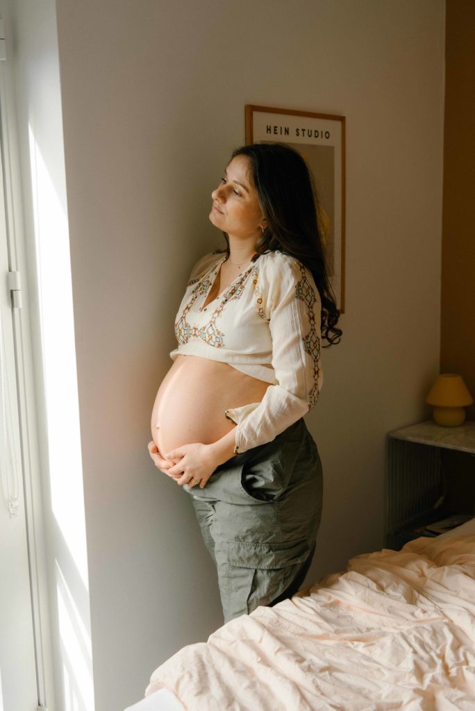 Amalie Bendixen står med hænderne på sin gravide mave