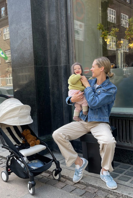 Bea Fagerholt sidder på bænk med baby og klapvogn