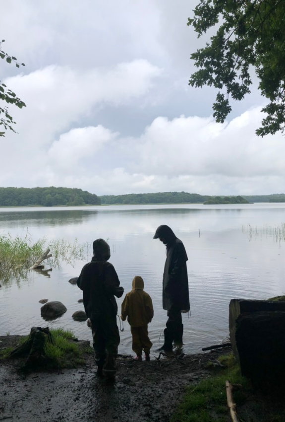 familie i regntøj ved en sø