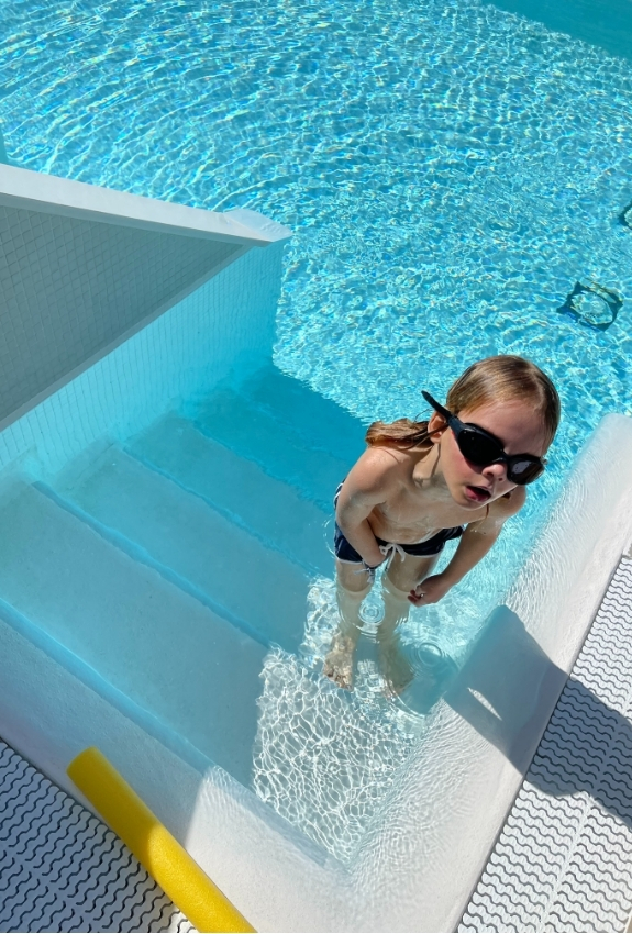 barn i pool med svømmebriller på 