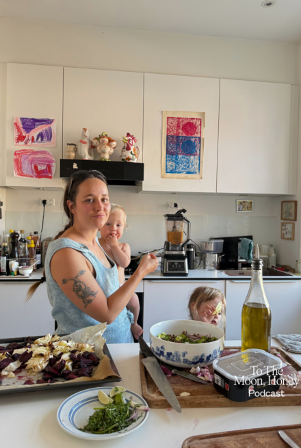 Kvinde i køkken med barn på armen