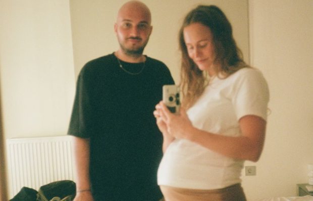 Mand og gravid kvinde poserer sammen foran spejl