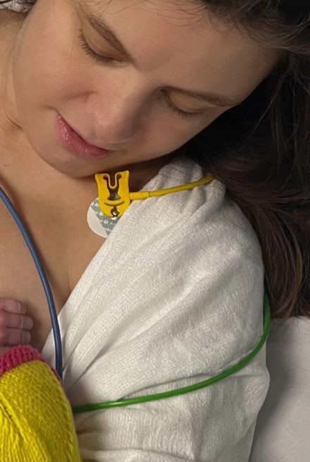 Kvinde i hospitalstøj med nyfødt baby