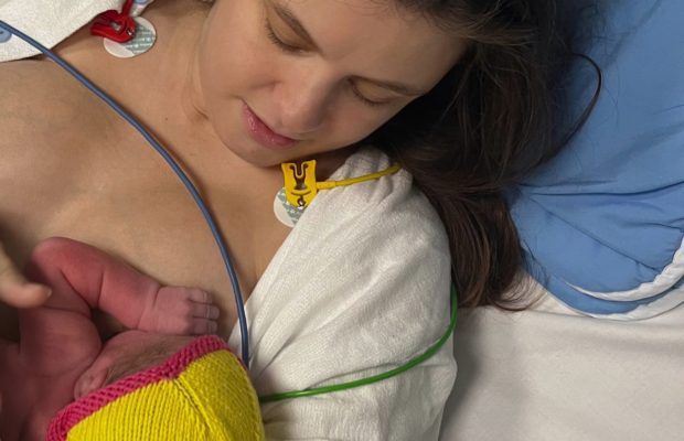 Kvinde i hospitalstøj med nyfødt baby