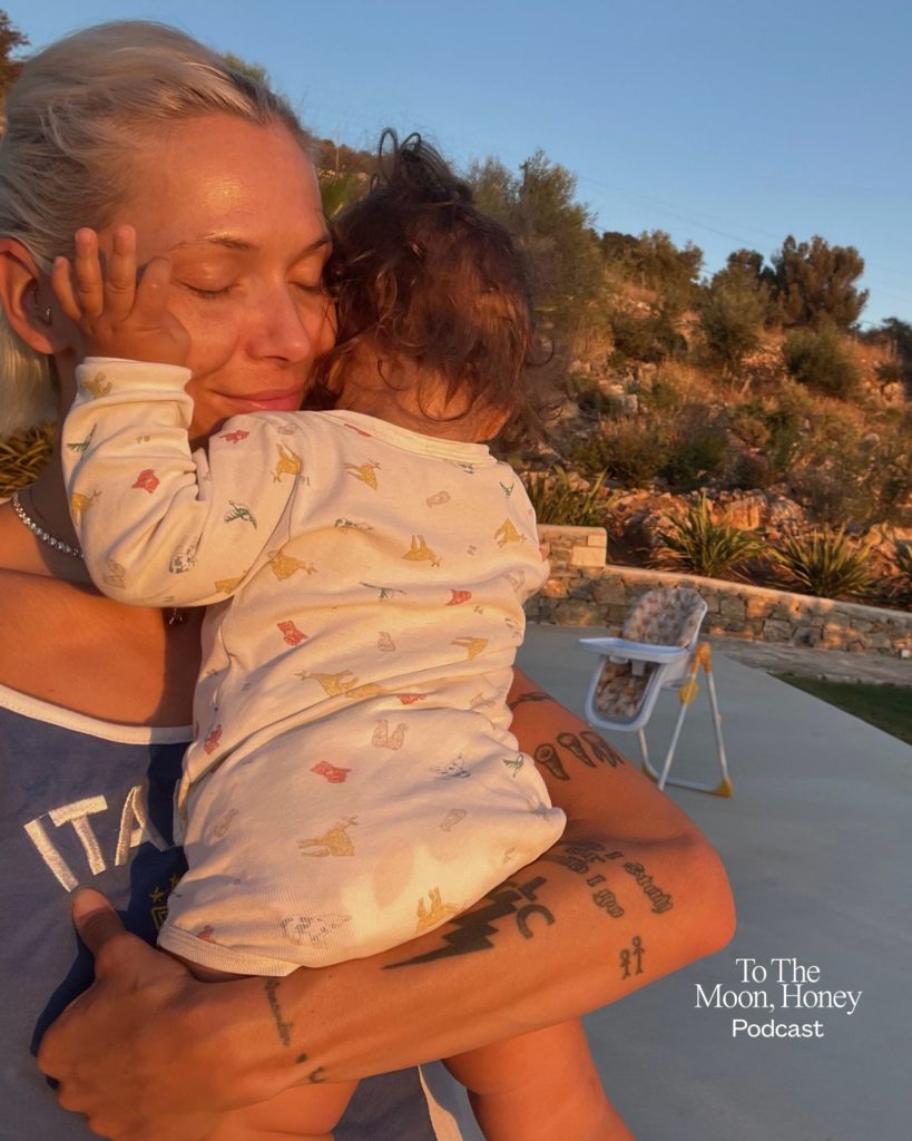 Kvinde krammer sit barn i aftensolen