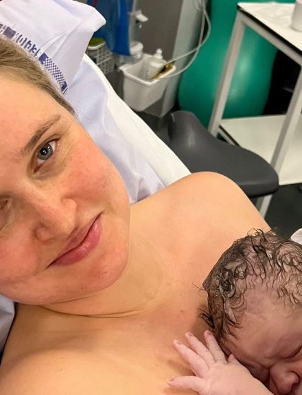 Mor med nyfødt baby på brystet