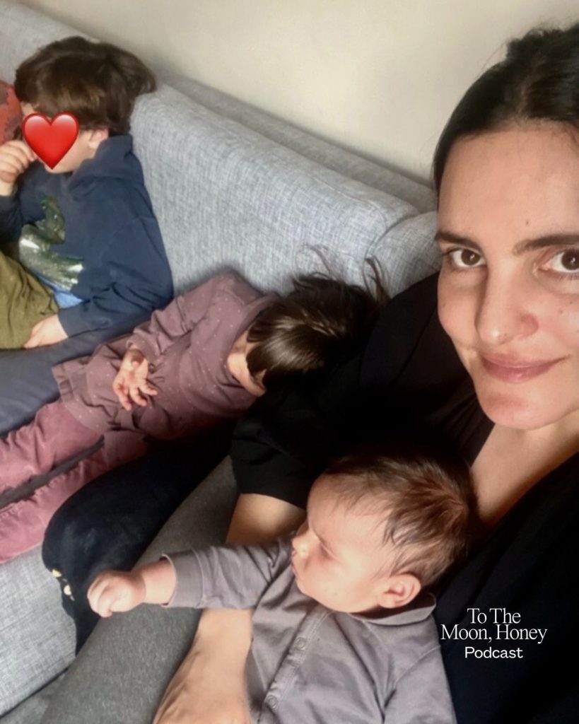 Kvinde siddende i sofa med sine tre børn