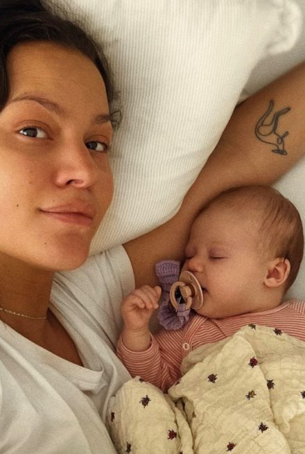 Kvinde liggende i seng med lille ny baby