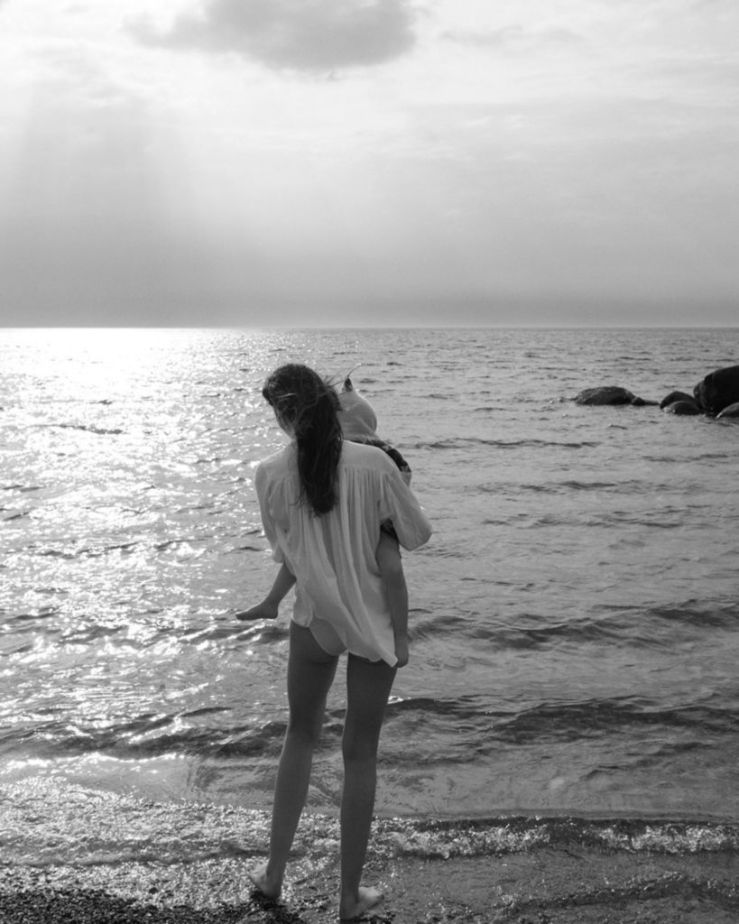 Kvinde med sit barn i vandkanten