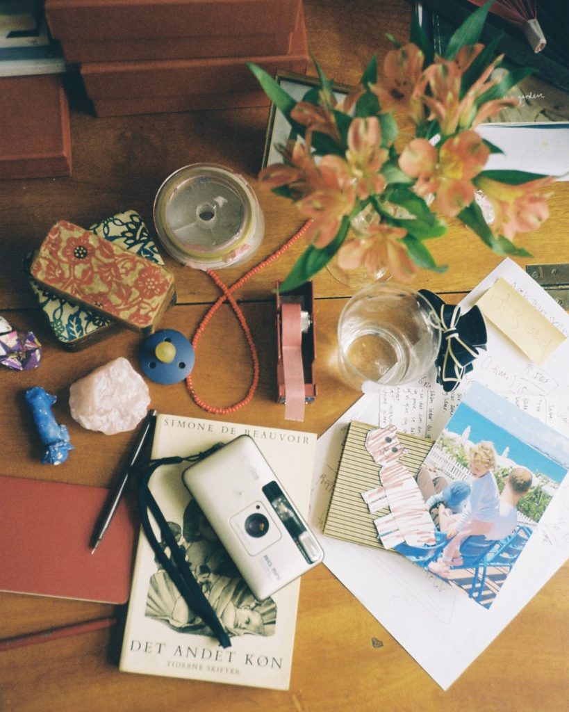 Et bord med bøger, kamera og andre ting på
