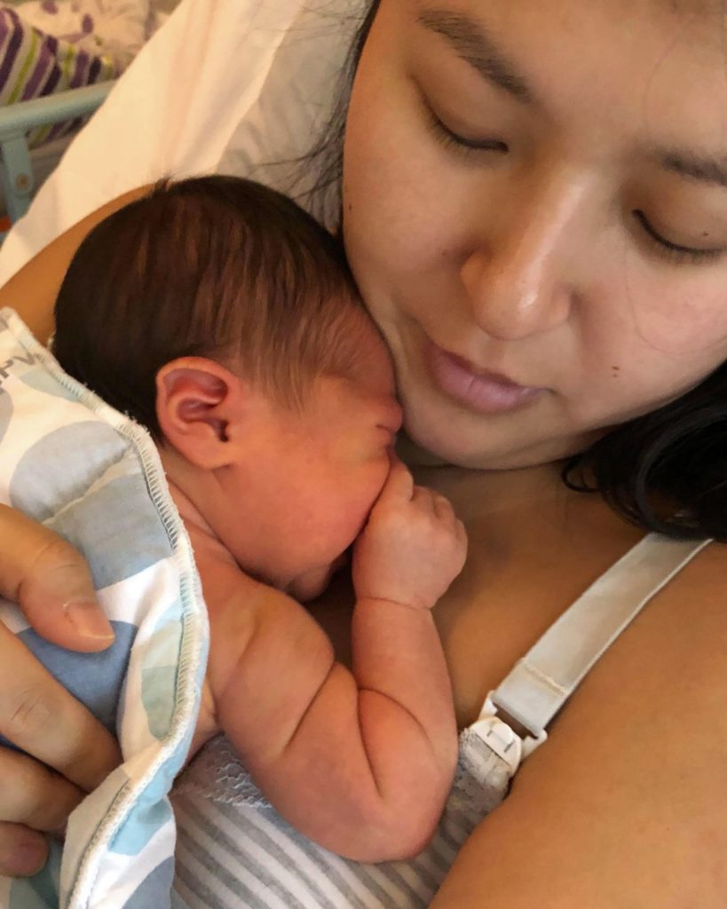 Kvinde med sin nyfødte baby på brystet