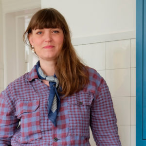 Anna fra 'Haven på taget' står i en ternet lilla og rød skjorte