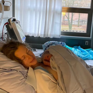 Mor på hospitalsseng lige efter fødsel med nyfødt baby i armene