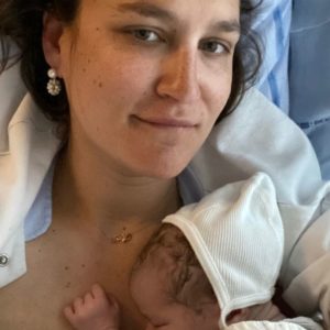 Kvinde i hospitalsseng med nyfødt baby