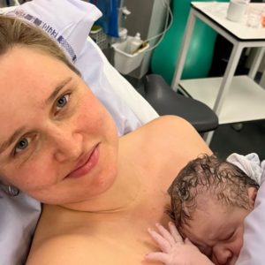 Mor med nyfødt baby på brystet