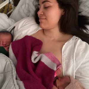 Nybagt mor med sine tvillinger på brystet