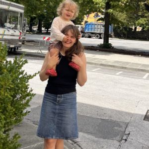 Mor med sit barn siddende på skulderen