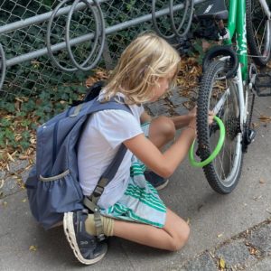 barn med skoletasken og en cykel - første skoledag